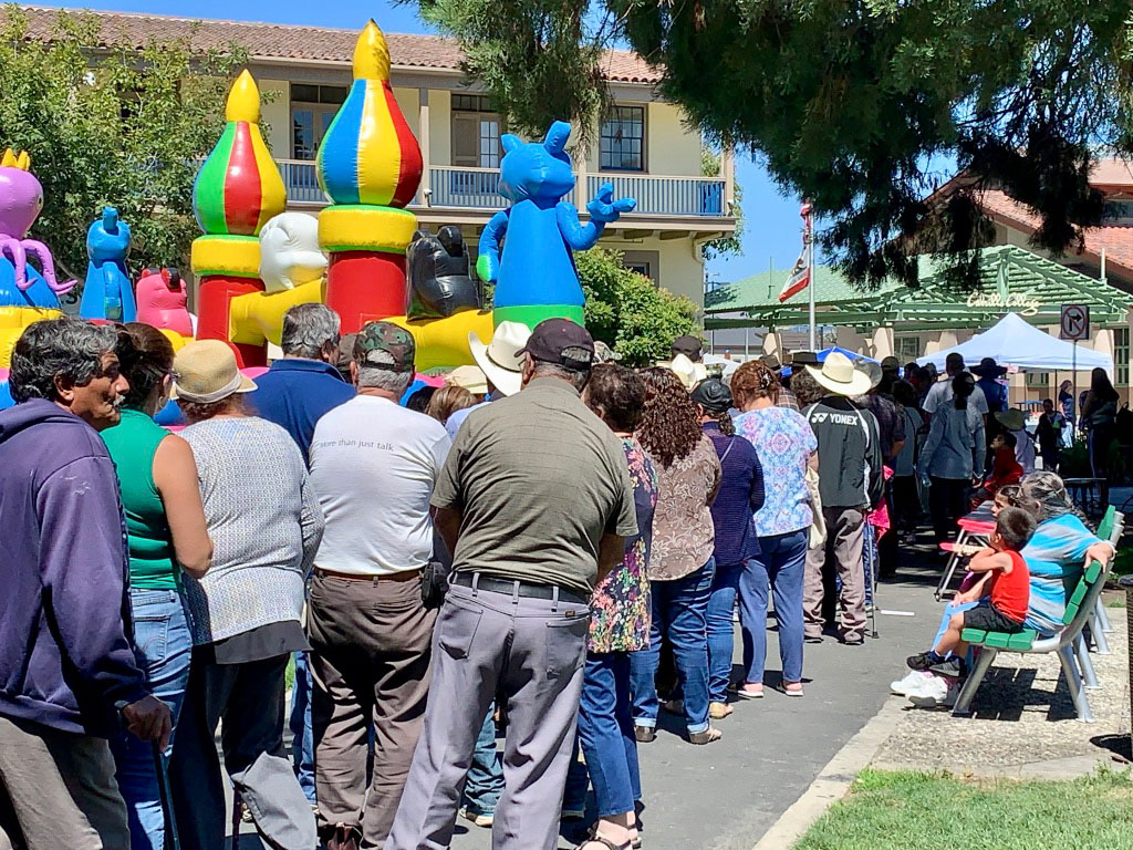 Seniors, many of them retired farm workers, line up for hours at the Watsonville Farmers Market to receive $20 vouchers towards fresh produce.