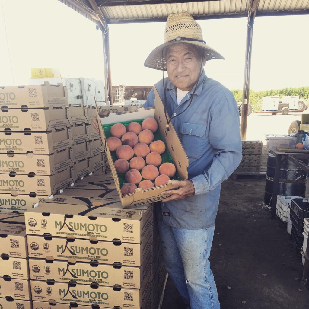 David Mas Masumoto holding a crate of peaches.