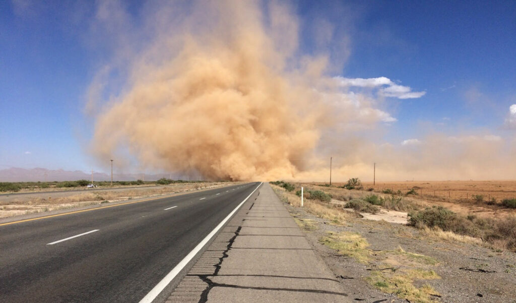 A cloud of sand obscures the vanishing point of a divided highway. A dust storm crossing I-10 in Arizona. Credit: Arizona Department of Transportation