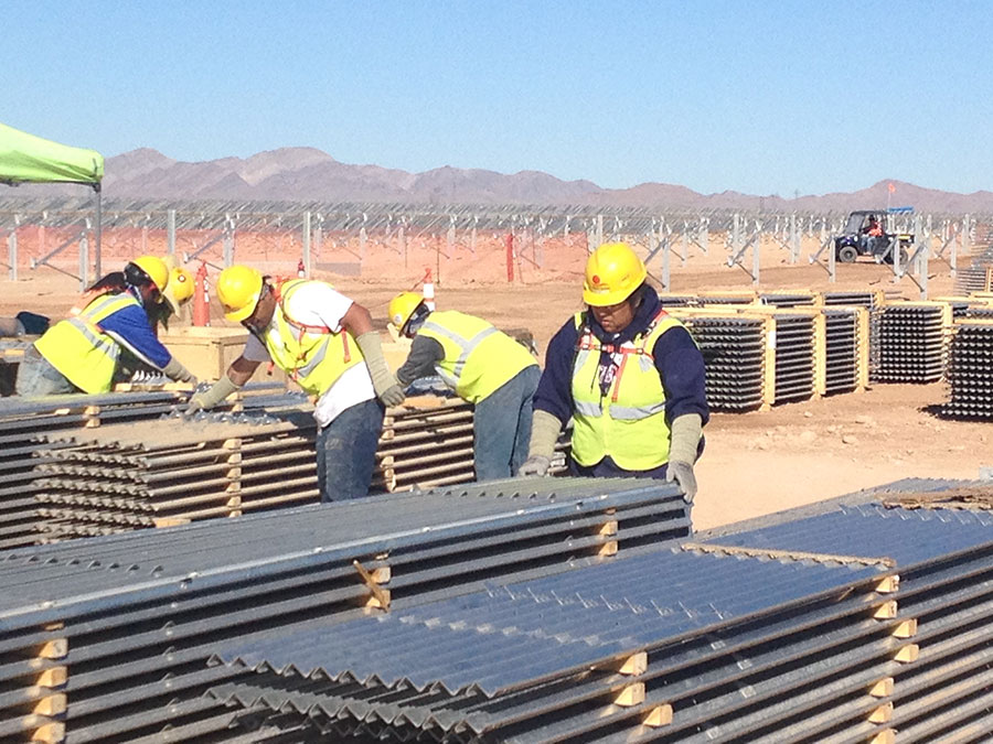 Workers unload solar panels.