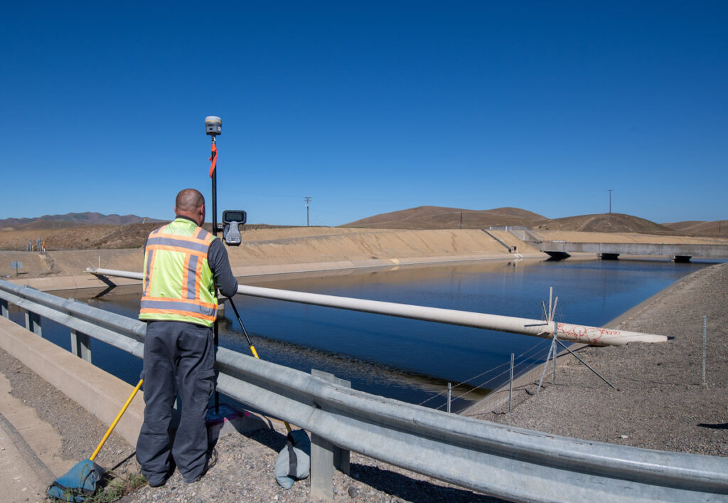 A surveyor with the California Department of Water Resources used tripod-mounted equipment to measure subsidence rates along the California Aqueduct embankment near the San Luis Reservoir in 2022.
Kelly M. Grow / California Department of Water Resources